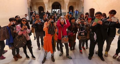 A group of tourists photographs the inside of the Alhambra.