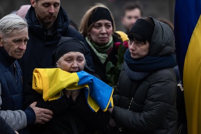 Un soldado entrega a la madre del soldado fallecido la bandera de Ucrania con la que han cubierto el féretro de su hijo en el cementerio de Lviv el 2 de marzo de 2022.