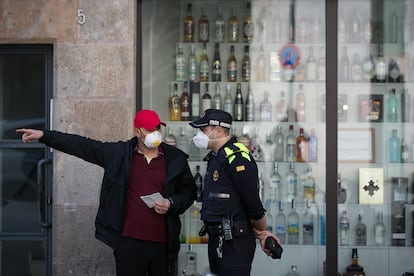 Un agente de la Guardia Urbana atendiendo a un ciudadano en el barrio del Raval.