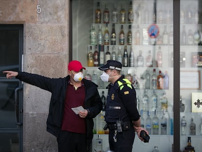 Un agente de la Guardia Urbana atendiendo a un ciudadano en el barrio del Raval.