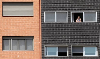 Una vecina se asoma a una ventana del edificio Memoria, de la EMVS, en la calle Barrileros.