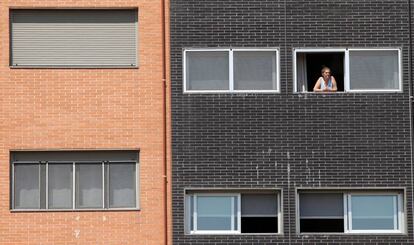 Una vecina se asoma a una ventana del edificio Memoria, de la EMVS, en la calle Barrileros.