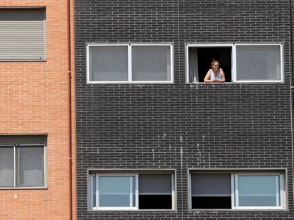 Una vecina se asoma a una ventana del edificio Memoria, de la EMVS, en la calle Barrileros.