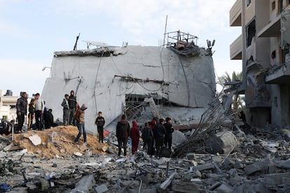 Un grupo de palestinos, junto a una casa destruida por un bombardeo israelí en Rafah, al sur de la franja de Gaza.