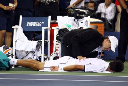 Djokovic es atendido por un fisioterapeuta durante el cuarto set.