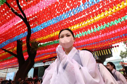 Miles de budistas se reúnen para celebrar el cumpleaños  de Buda que tradicionalmente se celebra en la luna llena del mes de mayo. En la imagen, una mujer con una vestimenta regional conmemoraba el domingo la efeméride en el templo de Jogyesa en Seúl, Corea del Sur, el domingo.