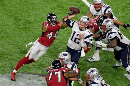 El quarterback de los New England Patriots, Tom Brady (12), es golpeado por el linebacker de los Atlanta Falcons, Vic Beasley (44) mientras lanza un pase en el segundo cuarto.