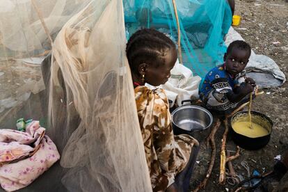 Una familia recién llegada desde Leer prepara un almuerzo sencillo en la puerta de su tienda de Bentiu.