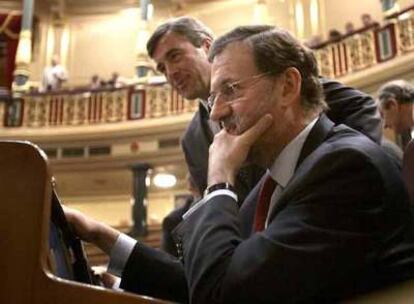 Mariano Rajoy y el secretario general del PP, Ángel Acebes, en sus escaños del Congreso.