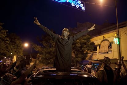 Youssou N&#039;Dour hace el signo de la victoria frente a manifestantes opositores anoche, en Dakar (Senegal).