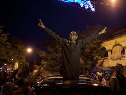 Youssou N&#039;Dour hace el signo de la victoria frente a manifestantes opositores anoche, en Dakar (Senegal).