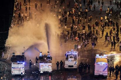 Milhões de torcedores franceses saíram neste domingo às ruas de Paris para celebrar a vitória, concentrando-se em sua maioria na icônica avenida da capital francesa, a Champs-Élysées. Na imagem, a polícial dispersa os torcedores com jatos de água.