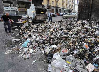 Dos trabajadores recogen basura ayer en una calle de Nápoles.