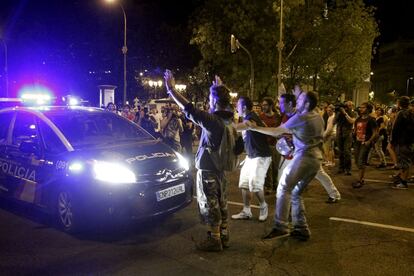 Algunos indignados tratan de impedir el paso a un coche de la Policía en las inmediaciones de Cibeles.