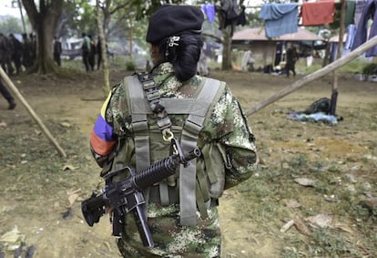 A member of the Revolutionary Armed Forces of Colombia (FARC), walks in a camp in the Colombian mountains on February 18, 2016. . Many of these women are willing to be reunited with the children they gave birth and then left under protection of relatives or farmers, whenever the imminent peace agreement puts an end to the country's internal conflict. AFP PHOTO / LUIS ACOSTA