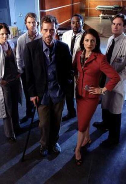 El doctor  House (Hugh Laurie), rodeado de compañeros de reparto.