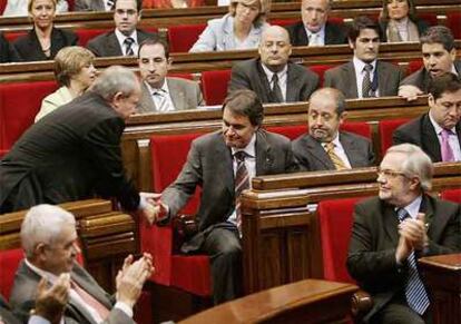 José Montilla, a la izquierda, se levanta de su escaño para estrechar la mano del líder de CiU, Artur Mas.