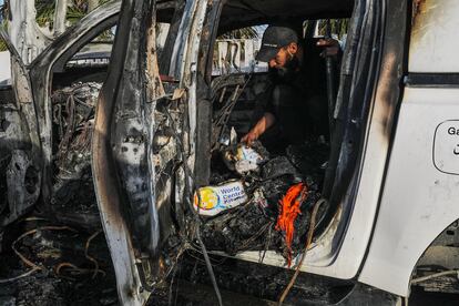 Un hombre examina el interior del coche destrozado del convoy de la ONG World Central Kitchen, tras un ataque israelí en el sur de Gaza.