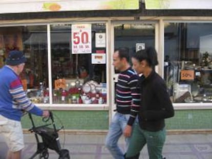 Varias personas pasan delante de un comercio de Vila Real de Santo António, en Portugal. EFE/Archivo