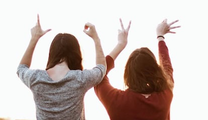 Dos mujeres componen la palabra LOVE.