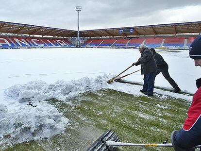 Operarios retiran la nieve en el estadio de Los Pajaritos de Soria, donde jugará el Madrid el domingo.