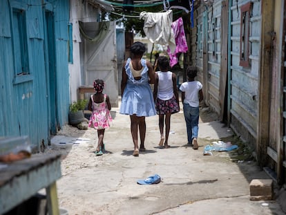 Abigail (centro) camina con niños haitianos que habitan en la comunidad de Friusa, en Punta Cana, República Dominicana.
