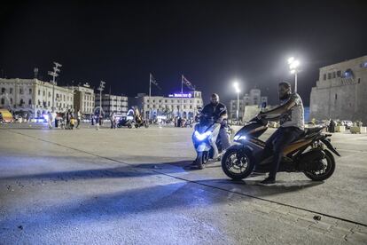 Dos hombres posan junto a sus motos en la plaza de los Mártires en el centro de la capital libia. En esta plaza se mezclan familias paseando con los acelerones de estos aficionados a las scooters.
