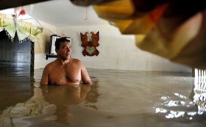 Un hombre al interior de su casa inundada en Juanchito (Departamento de Valle del Cauca), en 2012.