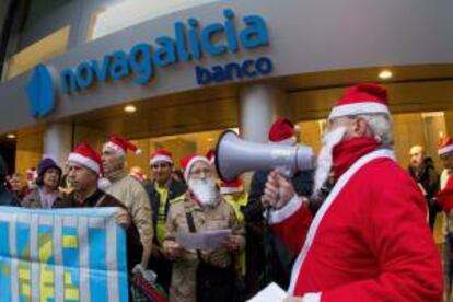 Un centenar de afectados por las participaciones preferentes y deuda subordinada de Novagalicia Banco se manifiestan ante la sede central de esta entidad en Vigo. EFE/Archivo