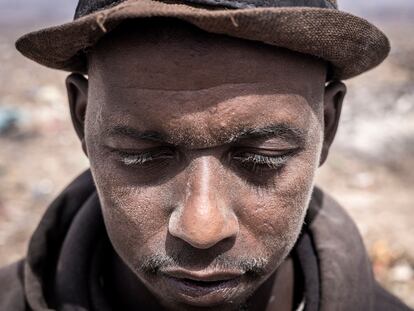Mamadou, un reciclador de Guinea, posa para un retrato con el rostro cubierto de polvo en el basurero de Mbeubeuss, en Dakar, el 14 de julio de 2021.