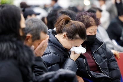 Familiares y amigos de los pasajeros del avin siniestrado lloran mientras esperan noticias en el aeropuerto de Muan, este domingo.