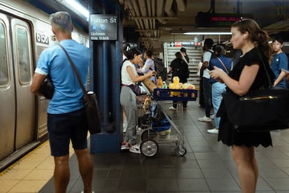 A young woman sells fruit on the Fulton Street platform.