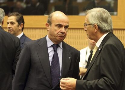 Guindos conversa con Juncker en el reciente Eurogrupo.