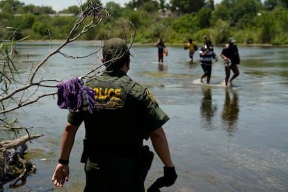 Un agente de la patrulla fronteriza observa el cruce de inmigrantes en el río Bravo, en Texas