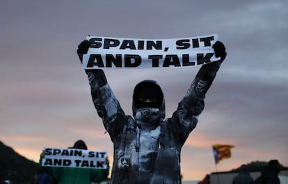 Un manifestant sosté un cartell amb el lema "Spain, sit and talk" (Espanya, asseu-te a parlar) durant el bloqueig de la frontera, aquest dimarts.