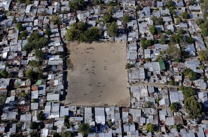 Unos muchachos juegan al fútbol en la villa miseria de La Cava en Buenos Aires. Deporte nacional por excelencia, el fútbol nunca ha sentido las crisis económicas argentinas y ha permitido a muchos jóvenes escapar de la pobreza. Argentina, 12 de abril de 2003.