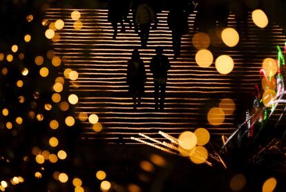 Una pareja camina por unas escaleras iluminadas en Tokio (Japón).