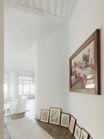 El blanco cegador inunda el salón principal del piso de Ana Viladomiu en La Pedrera, decorado con numerosas fotografías, grabados y pinturas.