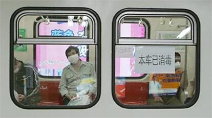 Los usuarios del metro de Pekín tratan de protegerse del mal con mascarillas.