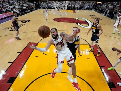 El alero del Miami Heat, Caleb Martin, pierde el control del balón cuando se dirige a la canasta contra  Nikola Jokic, de los Denver Nuggets, durante la primera mitad del Juego 4 de las Finales de la NBA.