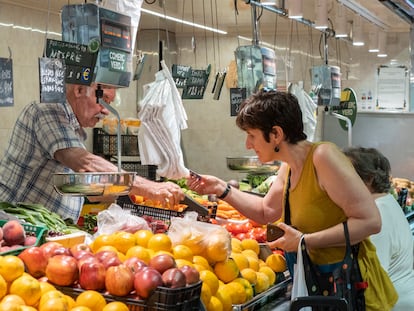 Una mujer paga su compra en una frutería de Barcelona.