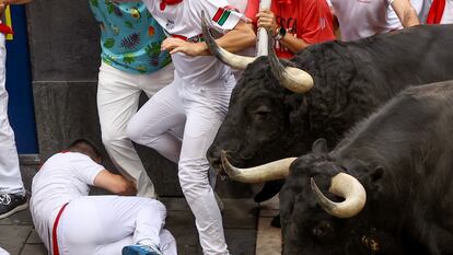 Los toros de la ganadería de Domingo Hernández a su paso por la curva de Mercaderes en el quinto encierro de los Sanfermines, este jueves en Pamplona.