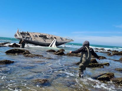 Unes persones s'apropen al veler 'Capitán III' a l'escull Salmedina, Cádiz.