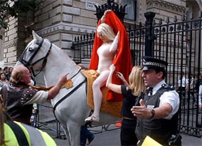 Manifestación de un grupo de trabajadores, encabezados por una estatua disfrada de Lady Godiva, cerca de la residencia del primer ministro británico, Tony Blair. PLANO MEDIO - ESCENA