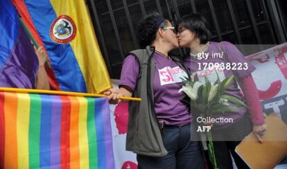 Elizabeth Castillo, con la bandera, besa a su novia Claudia Zea tras presentar los papeles para casarse. 