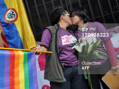 Elizabeth Castillo, con la bandera, besa a su novia Claudia Zea tras presentar los papeles para casarse. 