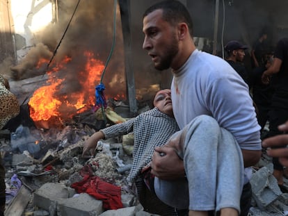 Un hombre traslada a una niña herida tras un bombardeo israelí en Rafah, al sur de Gaza, este viernes.