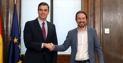 El candidato a la investidura, Pedro Sánchez, y el líder de Podemos, Pablo Iglesias, estrechan sus manos durante el acto de firma del acuerdo programático.