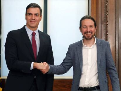 El candidato a la investidura, Pedro Sánchez, y el líder de Podemos, Pablo Iglesias, estrechan sus manos durante el acto de firma del acuerdo programático.