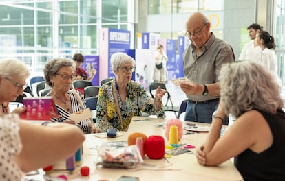 Un grupo de ancianos en un taller de costura en el vestíbulo del Hospital Sant Pau de Barcelona, convertido en refugio climático.